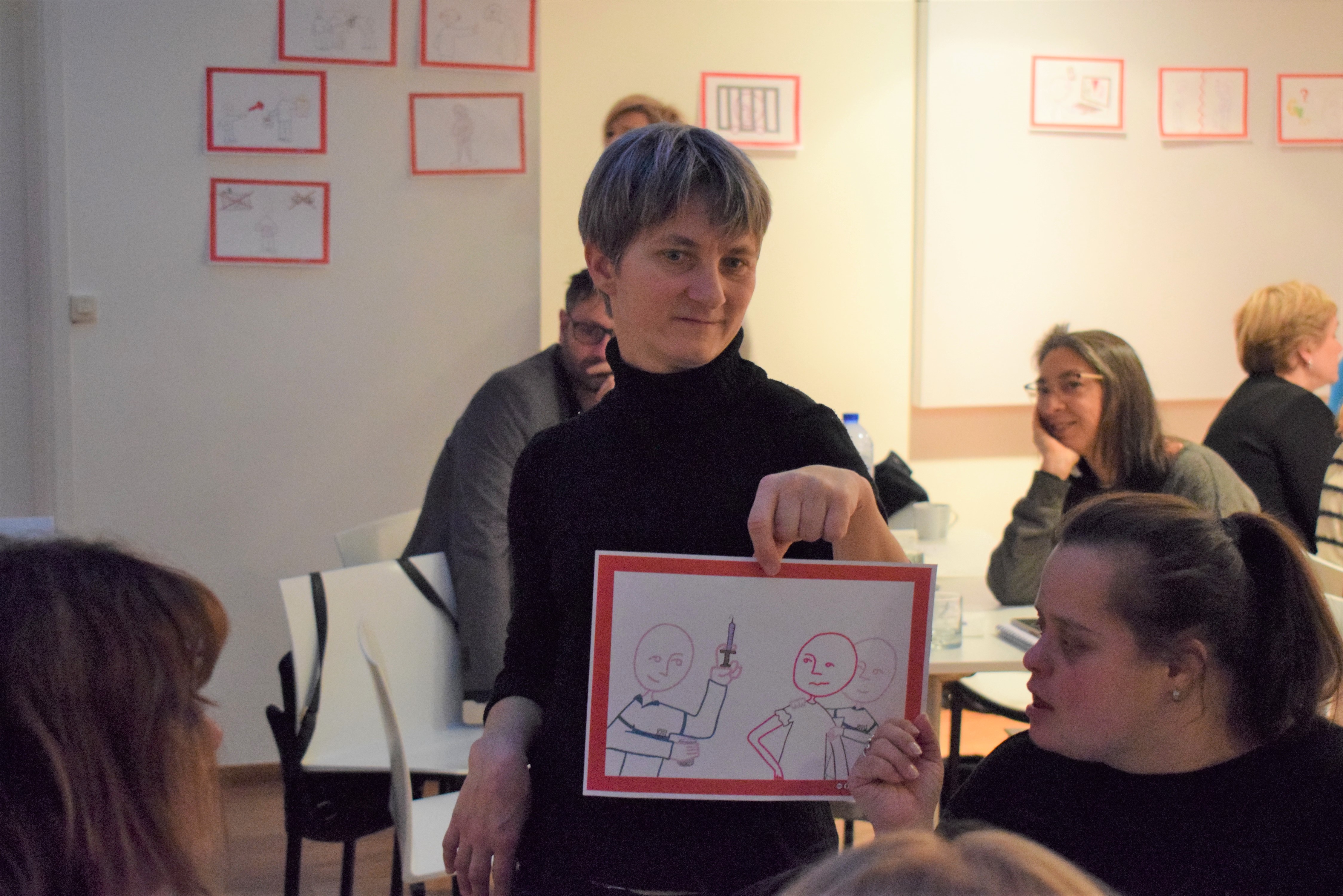 Senada Halilčević presenting a picture illustrating a type of violence