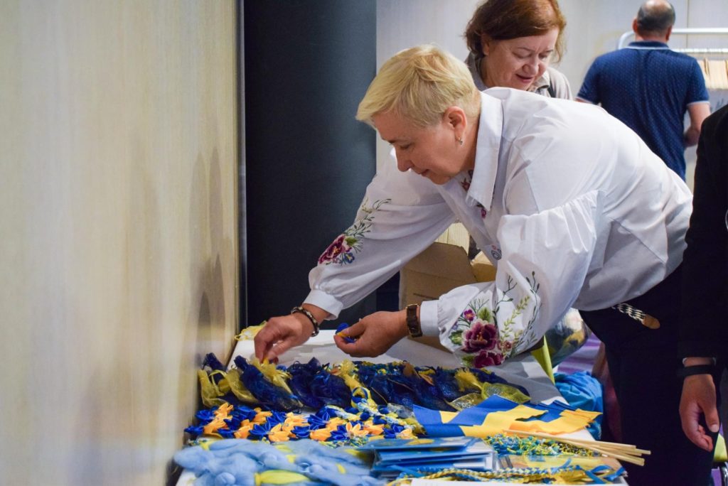 Olena Kravchenko arranging flags and hearts made by Ukrainian people with disabilities